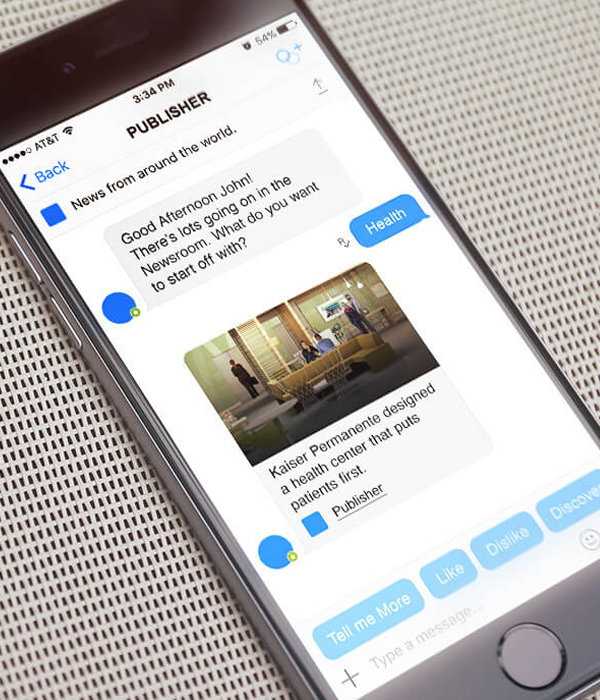 A man's hand hold a mobile phone displaying a news chatbot